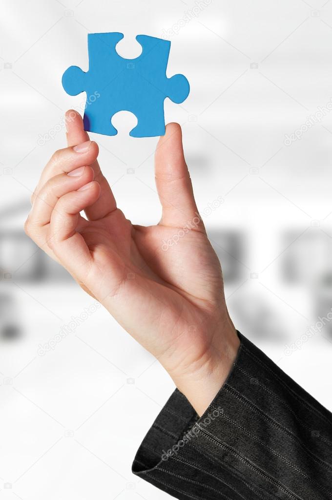 Business concept: Hand holding the missing jigsaw puzzle