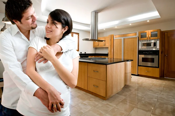 Jovem casal feliz sorrindo na cozinha da nova casa — Fotografia de Stock