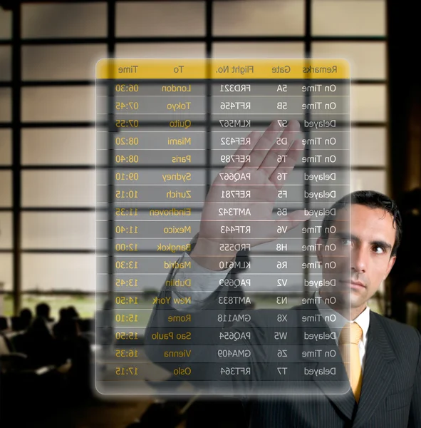 Liikemies valitsemalla hänen lennon lentokentällä digitaalisella futu — kuvapankkivalokuva