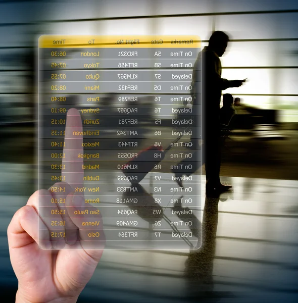 Hand choosing flights pushing a screen interface at the airport — Stock Photo, Image