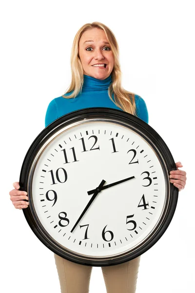 Молодая женщина в стрессе держит большие часы — стоковое фото
