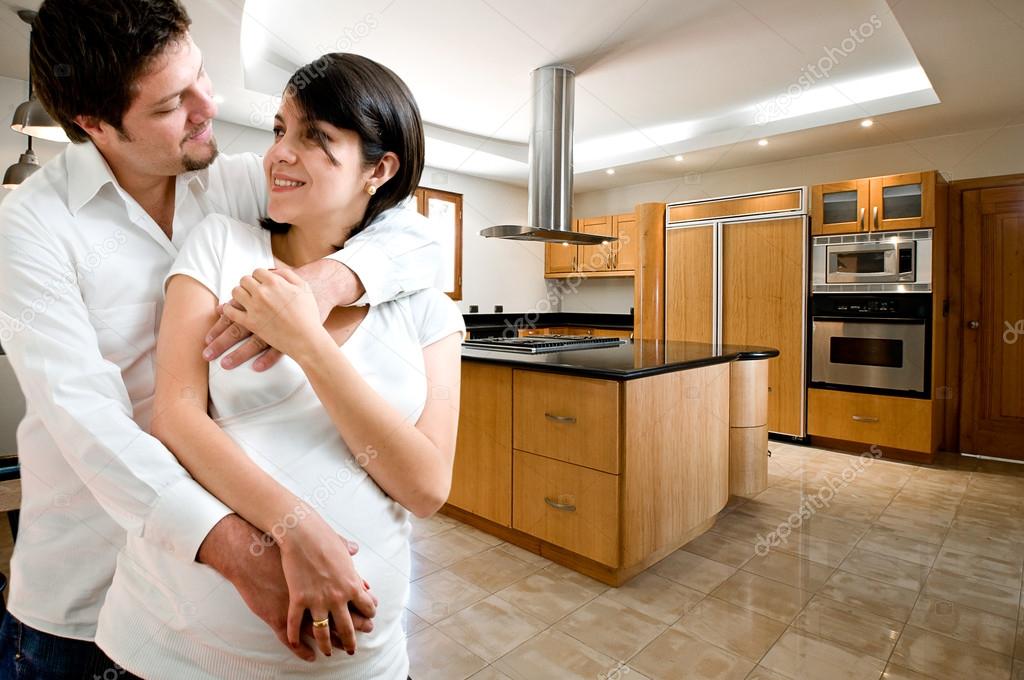Young happy couple smiling at kitchen of new house