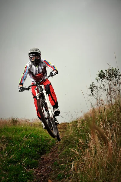 Jonge man rijden een berg fiets bergaf stijl — Stockfoto