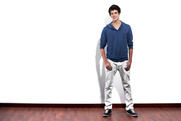 Young man relaxed against empty white wall with copy space — Stock Photo, Image