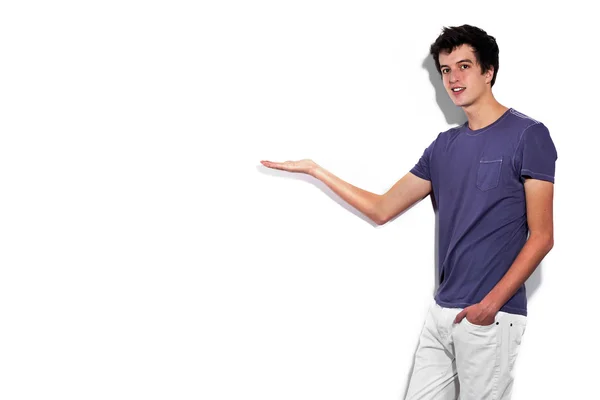 Young man relaxed pointing into the white wall — Stock Photo, Image