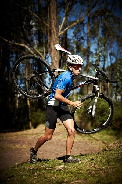 Young man running with a bike — Stock Photo, Image