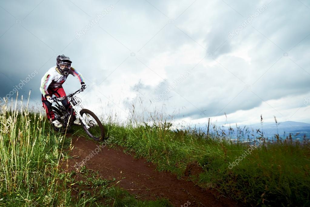 Young man riding a mountain bike downhill style