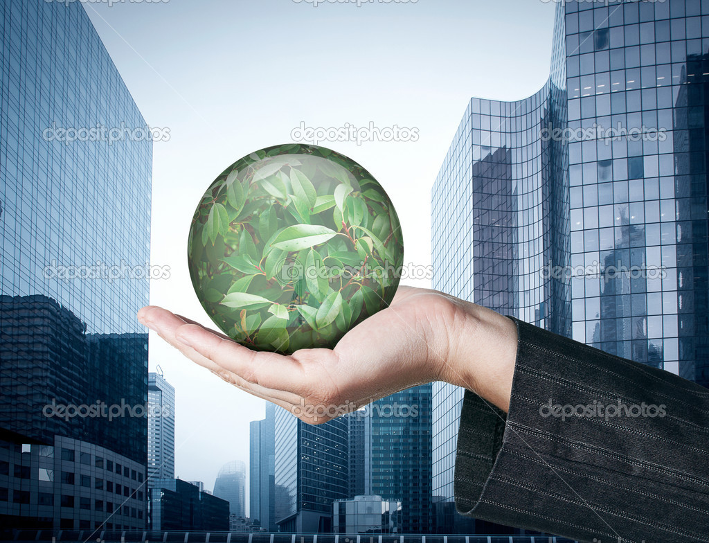 Ecology concept: Hand holding a globe with nature leaves on busi