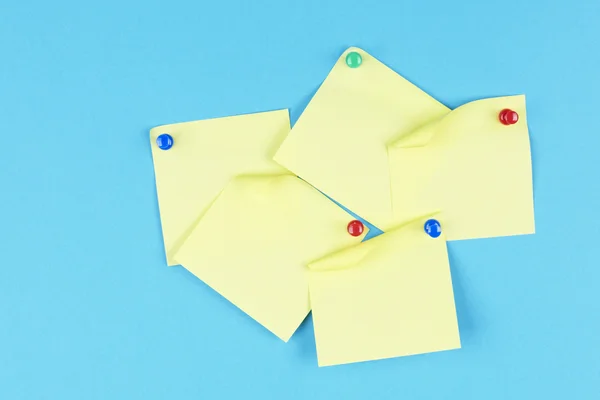 Žluté stickies připevněna kolíky na modrém pozadí — Stock fotografie