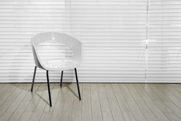 Design de interiores: cadeira branca moderna em piso de madeira e persianas — Fotografia de Stock