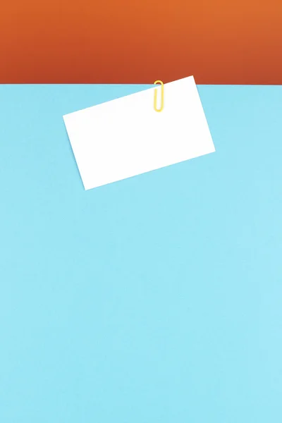 Biglietto da visita attaccato su un foglio blu con una clip gialla — Foto Stock