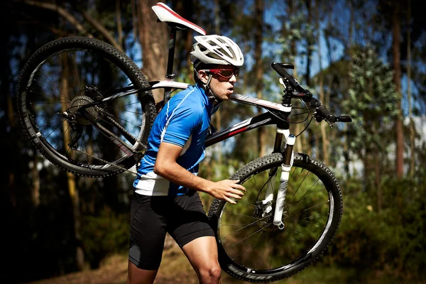 Jonge man loopt met een fiets — Stockfoto