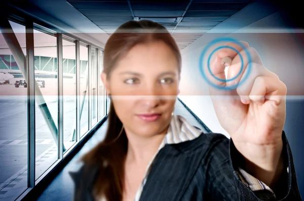 Busines woman at airport touching digital screen — Stockfoto