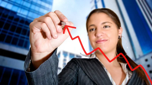 Business woman drawing a graph in the city — Stock Photo, Image