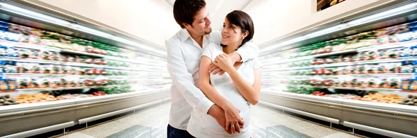 Young pregnant couple at supermarket — Stock Photo, Image