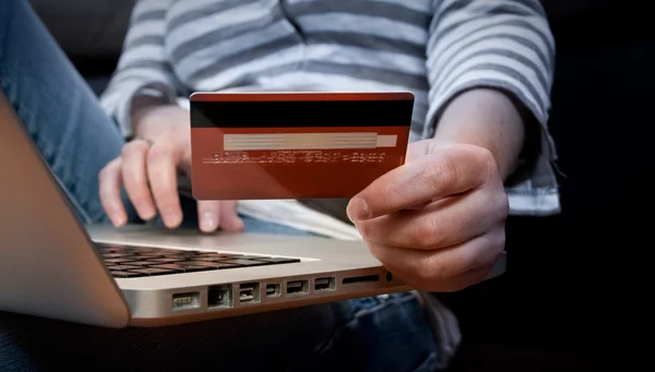 E-commerce concept: girl paying online with his credit card at h — Stock Photo, Image