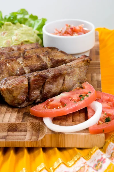 Ecuadorian food series: pork ribs with salad and pepper sauce — Stock Photo, Image