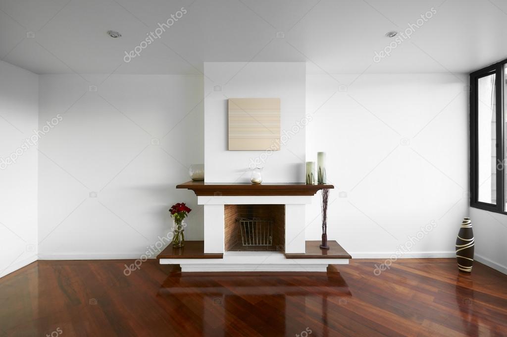 Big empty living room with a chimney, white wall and wooden floo