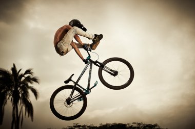 Genç adam onun bisiklet üzerinde uçan: kir atlama