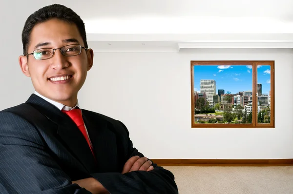 Hombre de negocios latino feliz aislado en oficina vacía con paisaje urbano —  Fotos de Stock