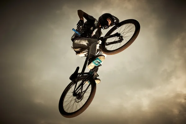 Junger Mann fliegt mit seinem Fahrrad: Drecksprung — Stockfoto