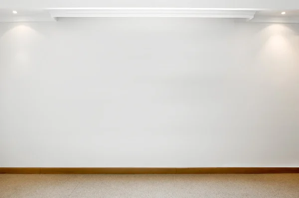 Leere weiße Wand mit 2 Scheinwerfern und Teppichboden — Stockfoto