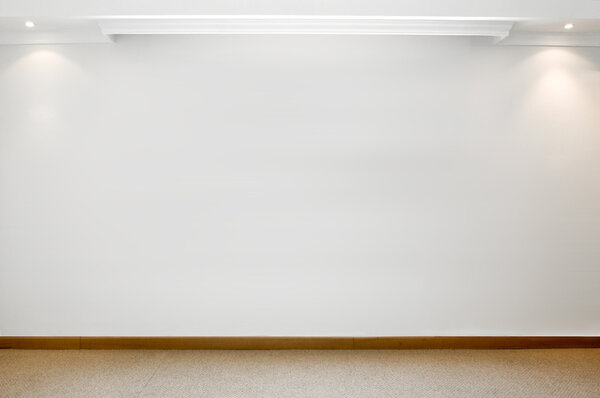 Empty white wall with 2 spot lights and carpeted floor