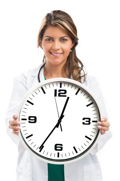 Doctora aguantando el reloj. Aislado sobre blanco — Foto de Stock