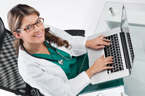Kvinna läkare vid skrivbord med laptop — Stockfoto