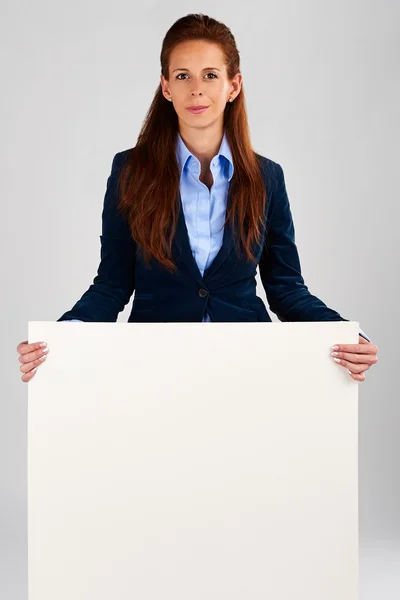 Une femme d'affaires prospère tenant une bannière blanche vide — Photo