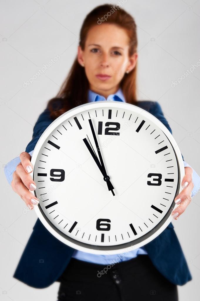 Time Concept: Business woman holding clock