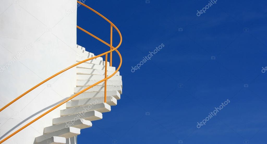 Curving white staircase against blue sky