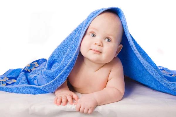 Un hermoso bebé bajo una toalla azul — Foto de Stock