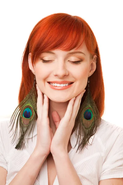 Portrait of young beautiful redhead woman with peacock earrings and closed eyes — Stock Photo, Image