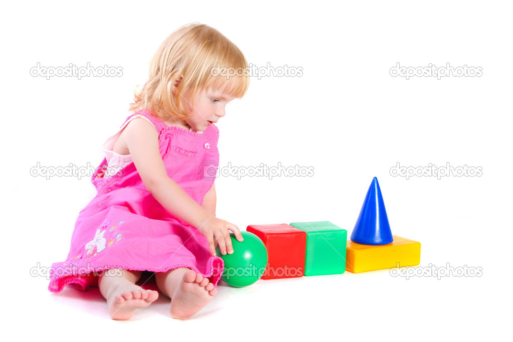 Baby in pink dress playing with bright blocks