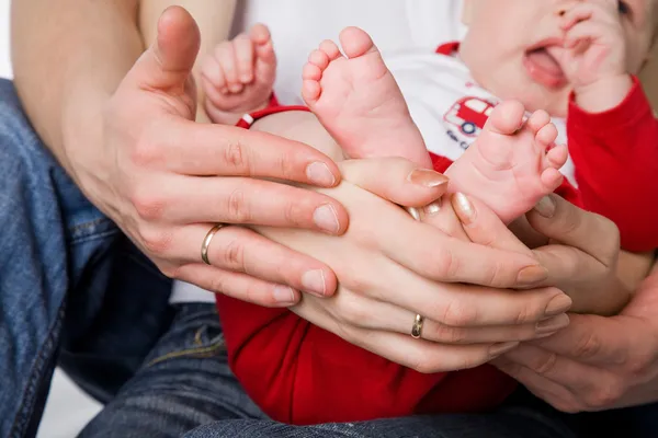 Mother and father holding litttle legs of their child — Stock Photo, Image