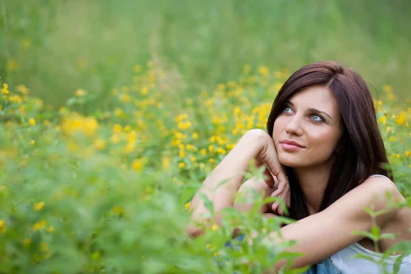 Brunette girl in jeans in the park — Stock Photo, Image
