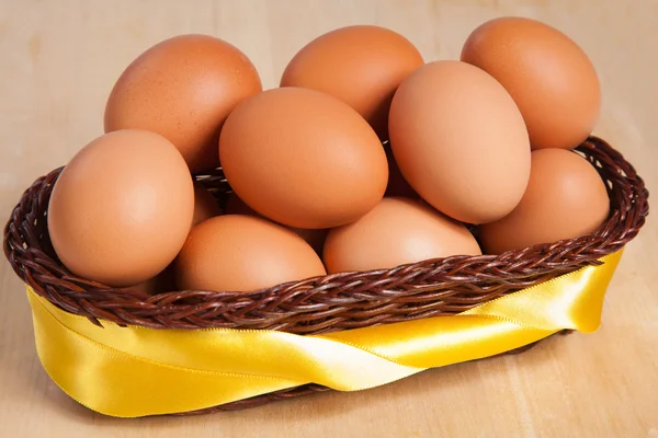 Huevos marrones en cesta con cinta amarilla — Foto de Stock