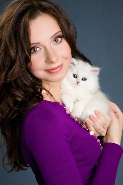 Mooi meisje in paarse jurk houden weinig witte kitten — Stockfoto