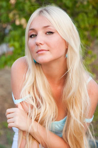 Schöne schöne blonde Frau gegen sonniges Grün im Freien — Stockfoto