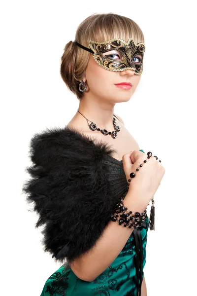 Beautiful girl in green evening dress with necklace and earrings in carnival mask hodling fan and beads — Stock Photo, Image