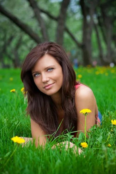 Schöne brünette Mädchen auf dem Gras — Stockfoto