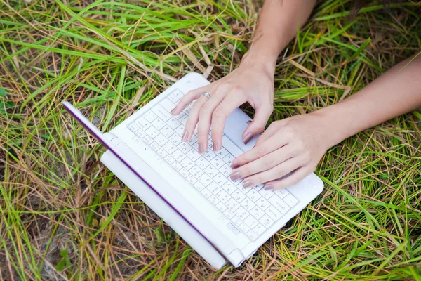 Manos de la mujer escribiendo en el ordenador portátil — Foto de Stock