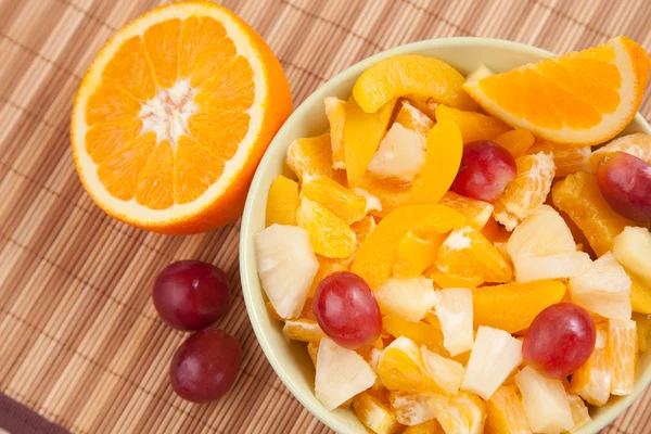 Bowl with fruit salad with half of orange — Stock Photo, Image