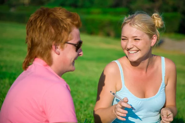 Blonde grappig meisje met rode hoofd schattige jongen in het park — Stockfoto