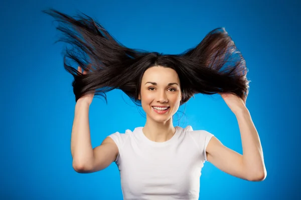 Grappige mooie brunette meisje bedrijf in haar lange haren — Stockfoto