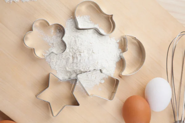 Zbiór cookie cutter formy wokół mąki na desce — Zdjęcie stockowe