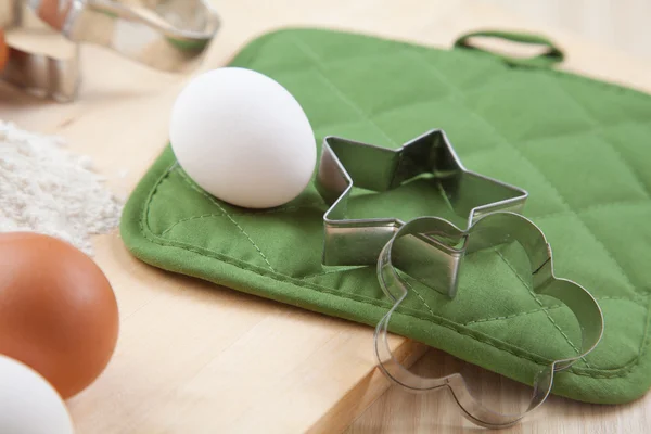 Dos moldes de galletas de plata con huevo blanco en mesa de madera — Foto de Stock