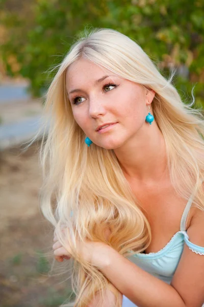 Lovely beautiful blonde woman against sunny outdoor greenery — Stock Photo, Image