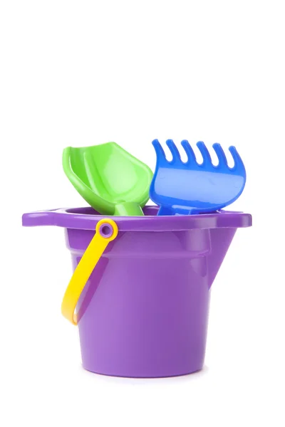 Toy purple bucket with spade and rake — Stock Photo, Image